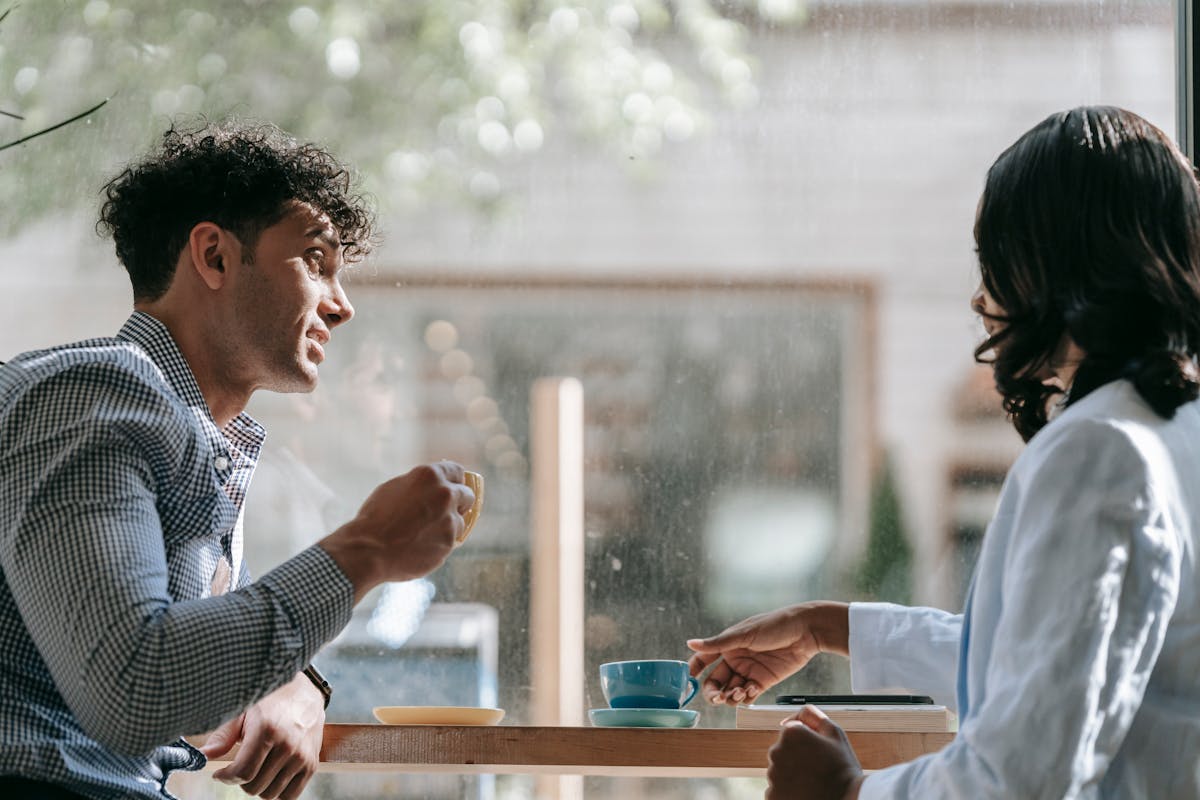 Two people having supportive conversation over coffee