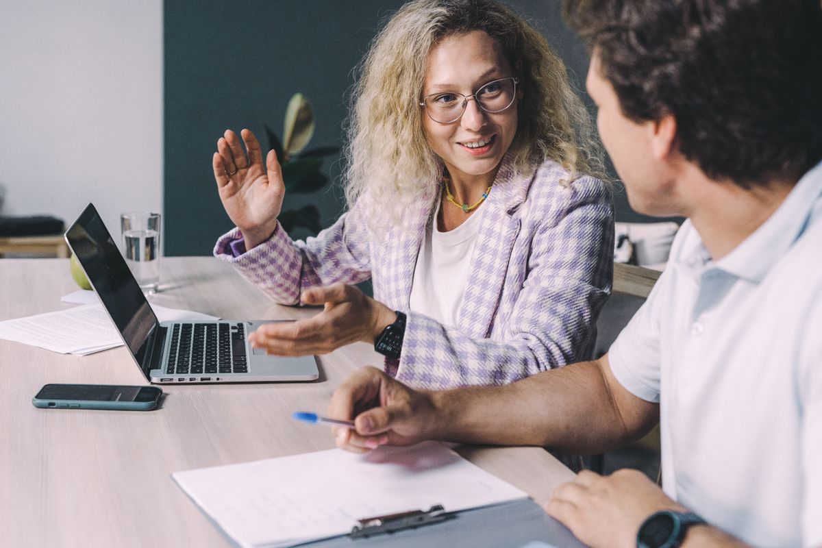 Two colleagues talking at an office desk
