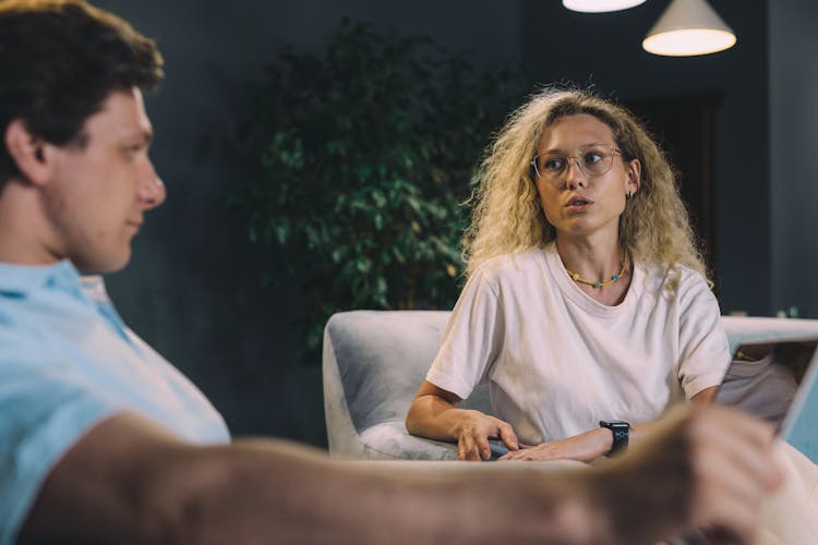 A Woman In White Shirt Talking To The Man Sitting Near Her