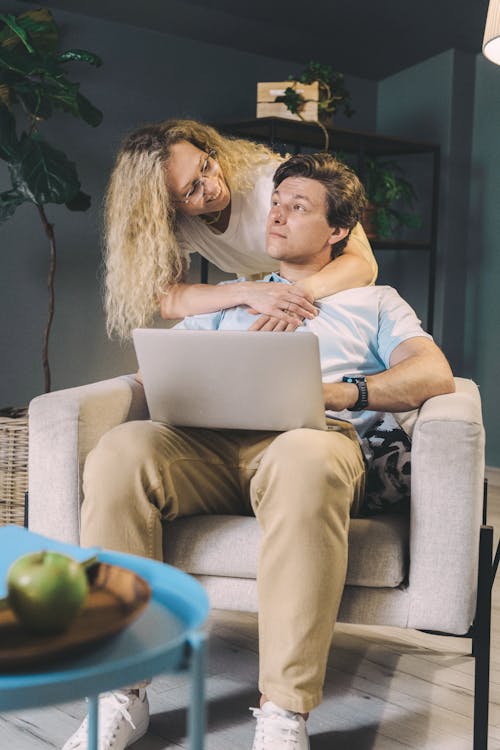 Free A Blonde Woman Hugging the Sitting Man from Behind  Stock Photo
