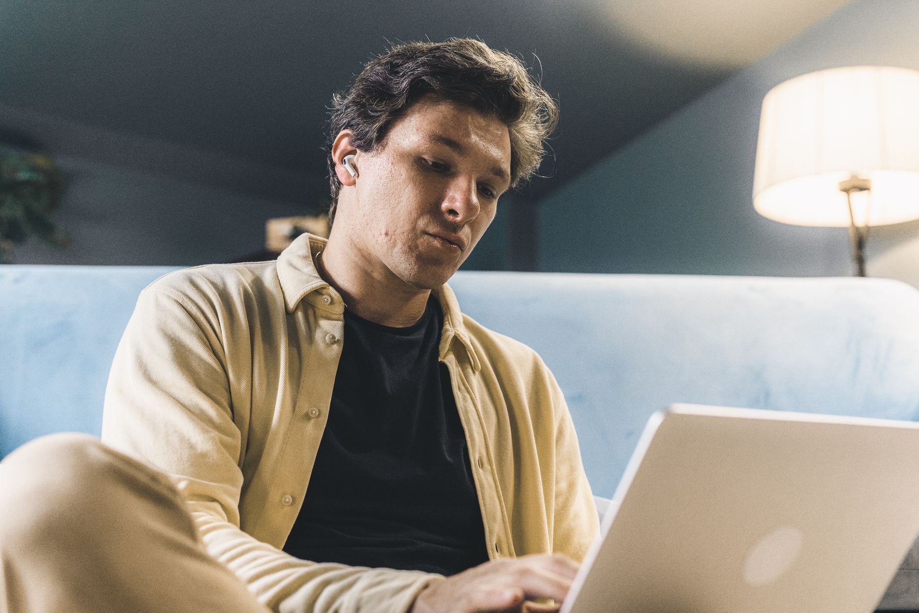 A focused bettor comparing live horse racing odds on a laptop beside race notes