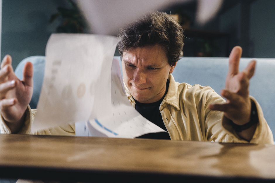 person frustrated desk paperwork banking documents