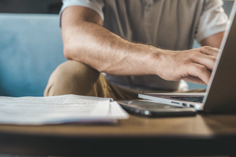 Man In A Gray Shirt Using A Laptop