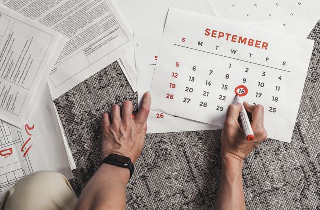 Hands circling an upcoming date on a paper calendar