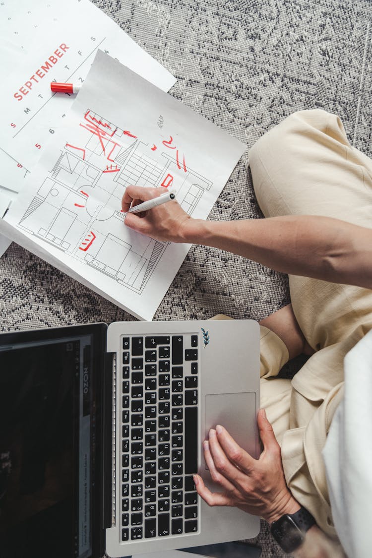 A Person Writing On The Floor Plan 