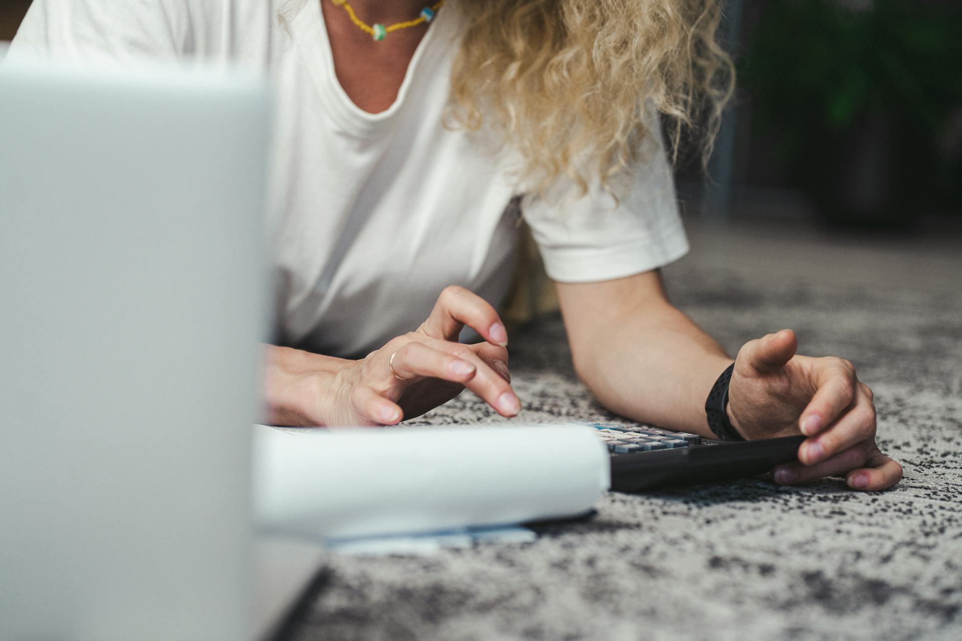 A woman engages in budget planning using a calculator on a comfortable carpeted floor.