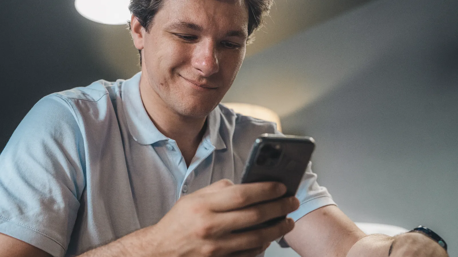 Man looking at his phone screen while sitting in an office setting