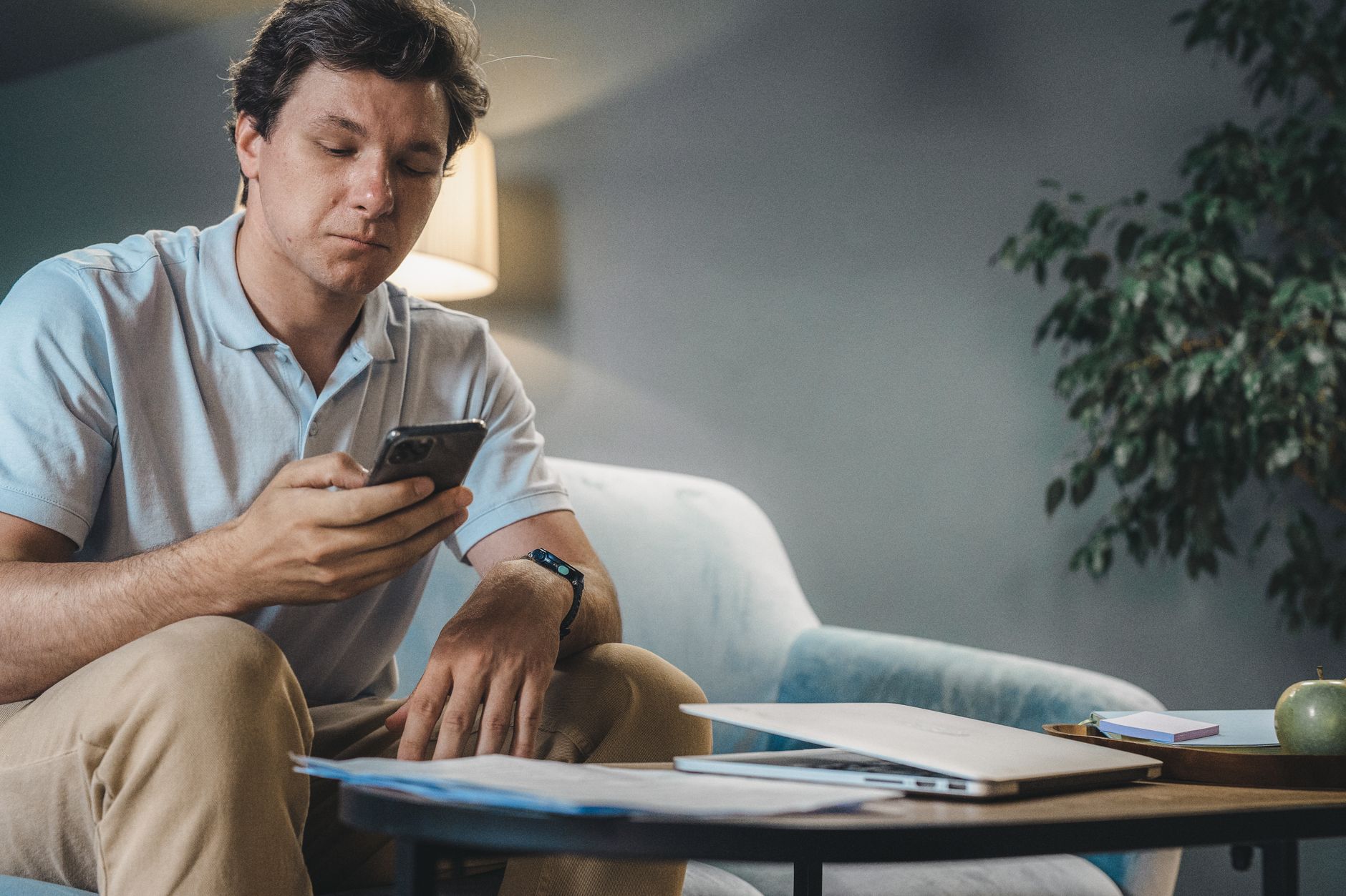 A person sitting on a sofa reading a document on a phone screen