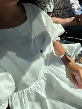 Casual summer outing with white dress, necklace, and wristwatch.