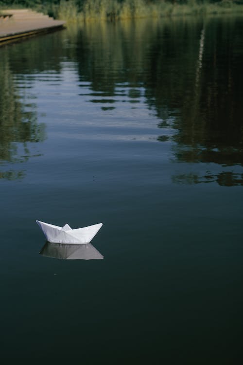 Paper Boat Floating on Calm Water