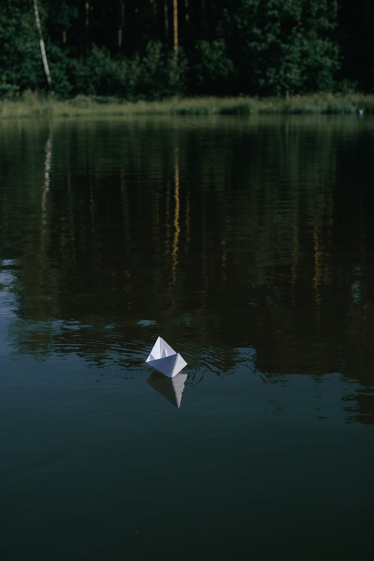 White Paper Boat Floating On The Lake 