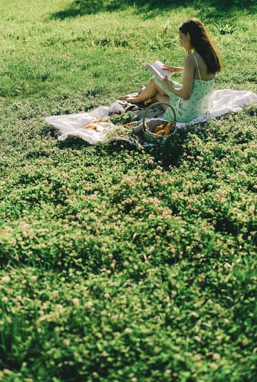A Woman in Green Dress Sitting on Grass Field