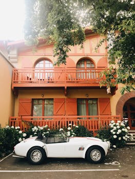 Classic white convertible parked in front of a vibrant rustic building in Arcachon, France.