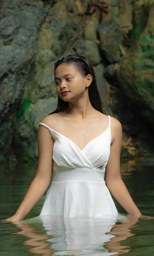 Woman in White Spaghetti Strap Dress Standing in Body of Water
