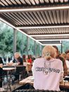 Woman in White Crew Neck T-shirt Sitting on Brown Wooden Chair