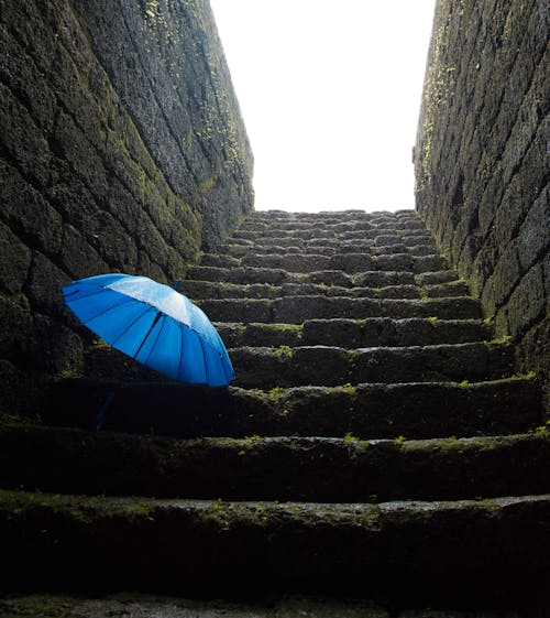 Free A Blue Umbrella on a Stone Staircase  Stock Photo
