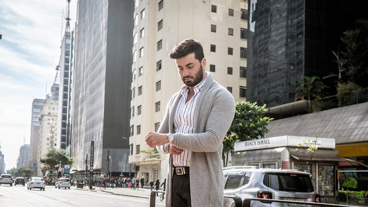 A Man In A Grey Cardigan Standing In The Street