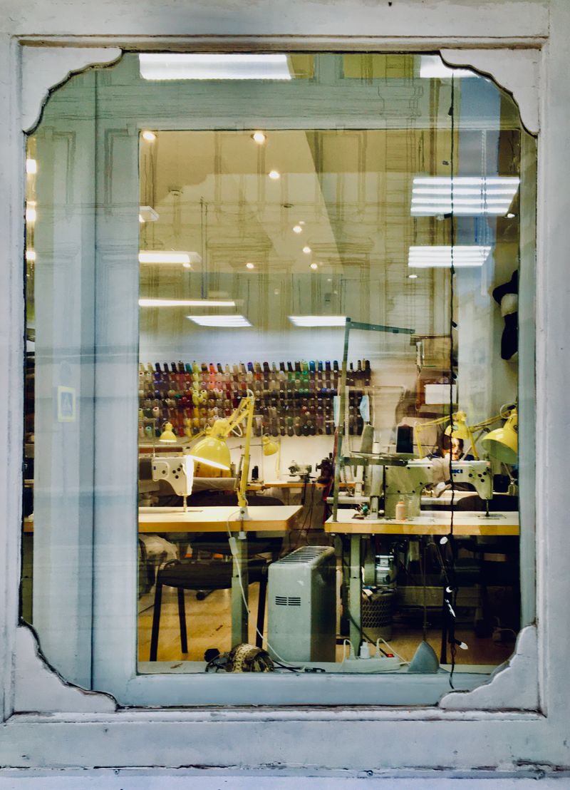Tailoring workshop seen through a shopfront window — Mary Ulanovskaya on Pexels