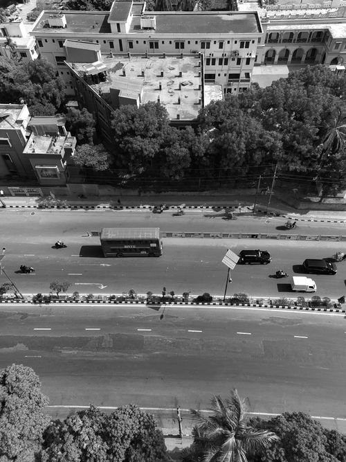 Free Drone shot of city street with vehicles in black and white, ideal for urban and travel themes. Stock Photo