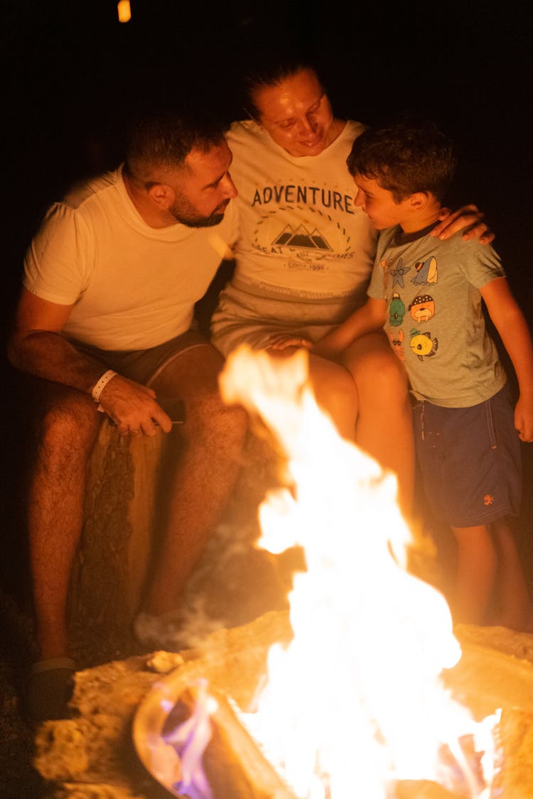 A Family Sitting Beside The Bonfire