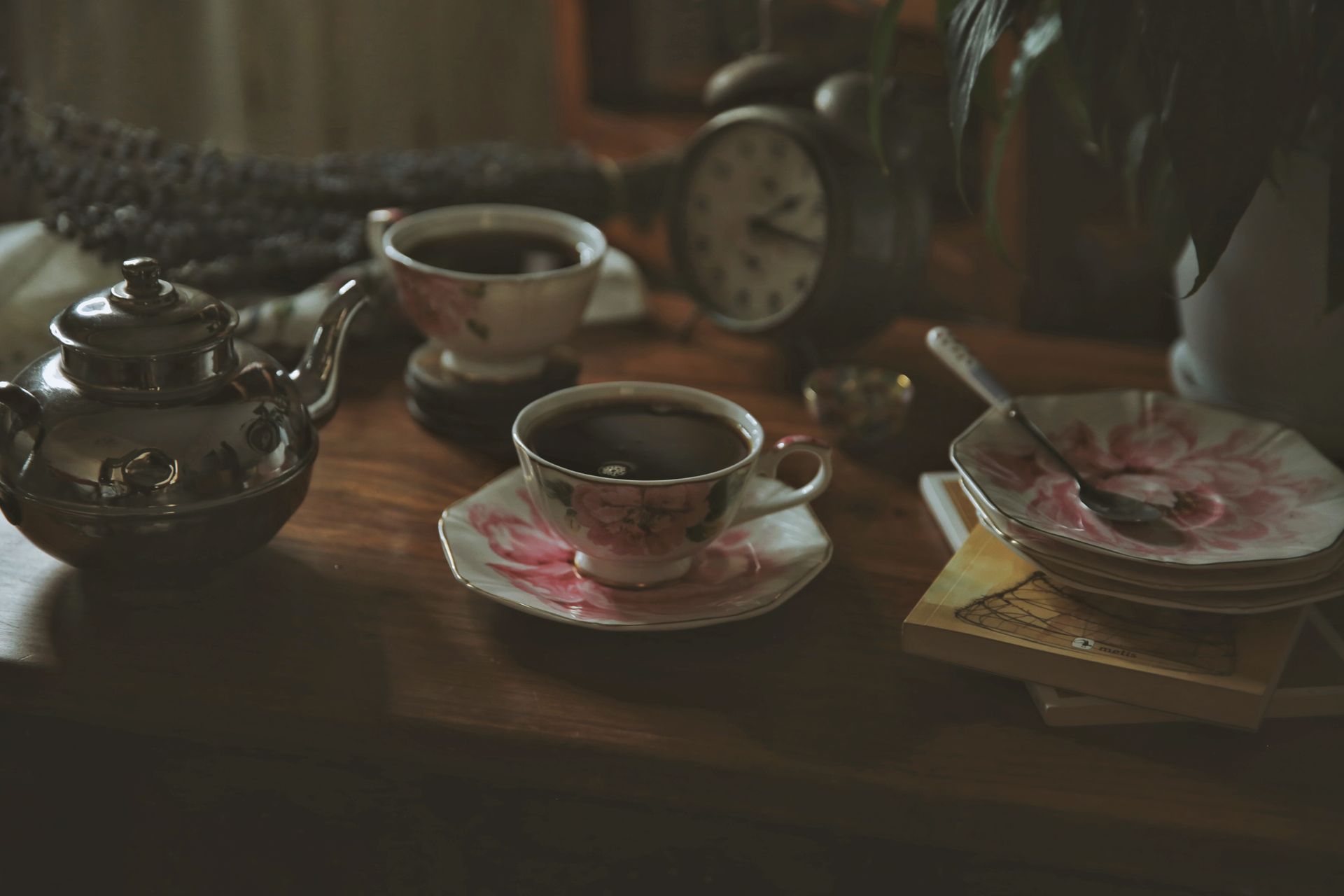 A warm and vintage tea setting with floral teacups and a teapot, perfect for a cozy afternoon.