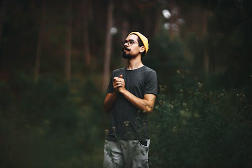 Free A Man Standing in a Forest with his Hands Clasped  Stock Photo