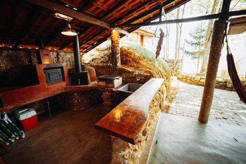 Free A rustic outdoor kitchen featuring a traditional wood-fired stone oven and wooden countertop. Stock Photo
