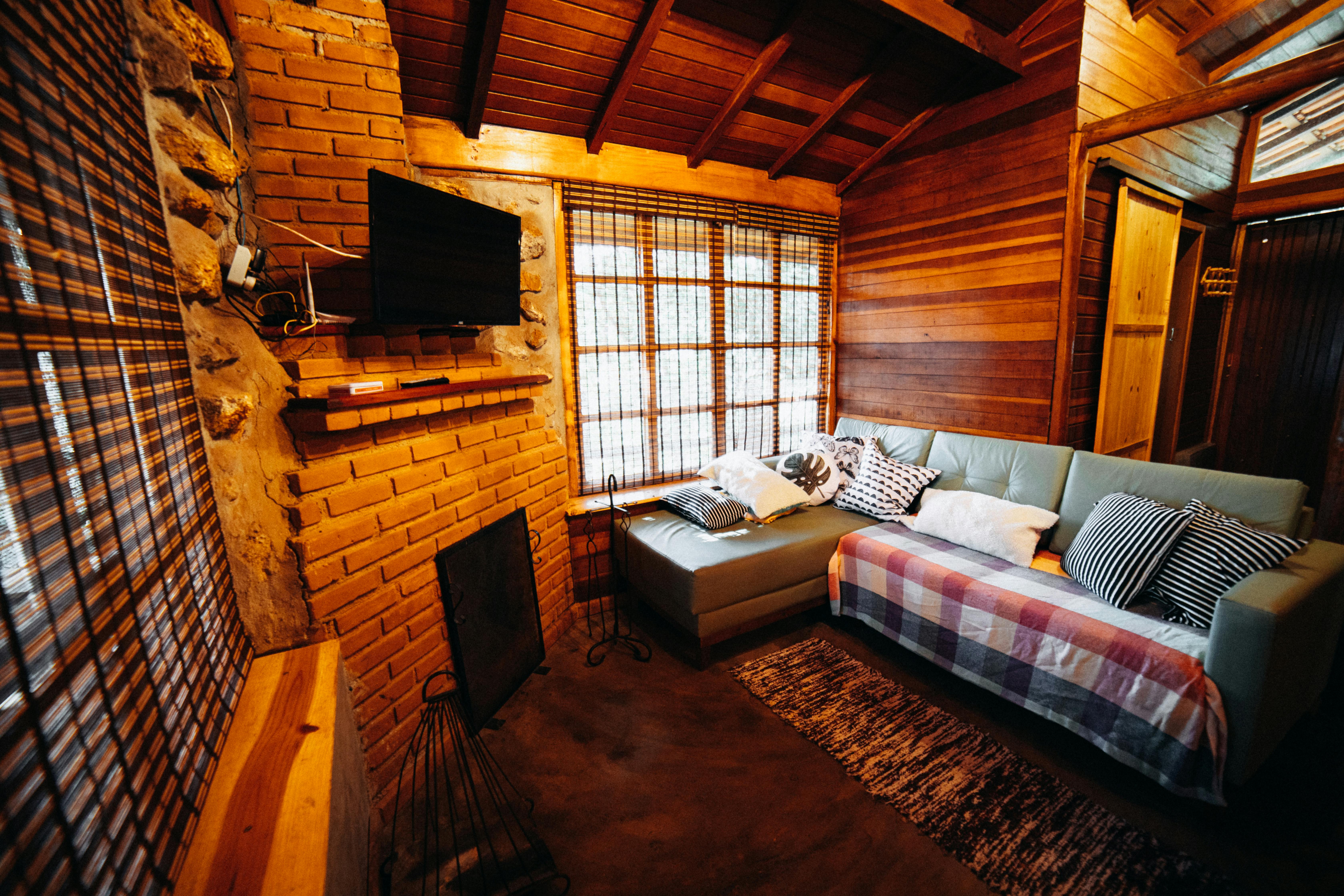 Tapczan z tkaniny w salonie domku letniskowego, jasne drewno i naturalne swiatlo