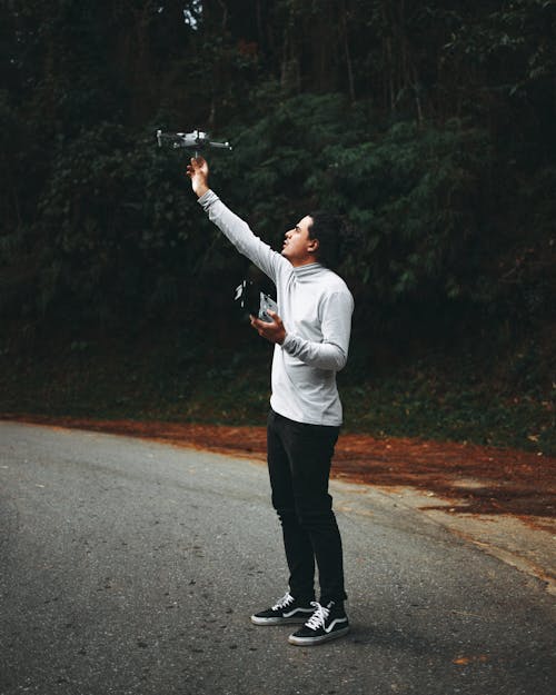 Free A Man in White Long Sleeve Shirt Holding Drone Camera Stock Photo