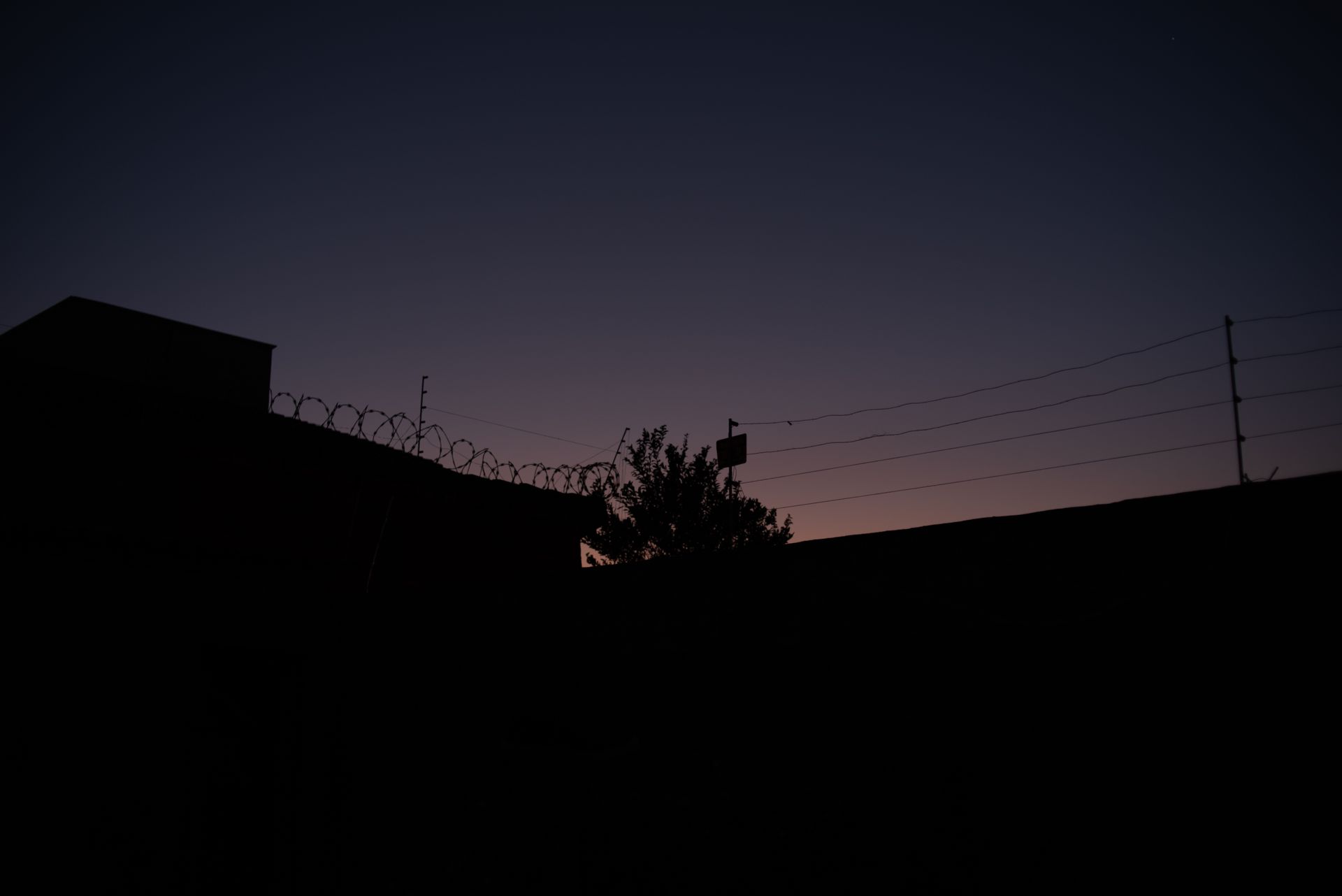Valla fronteriza y puesto de control al atardecer