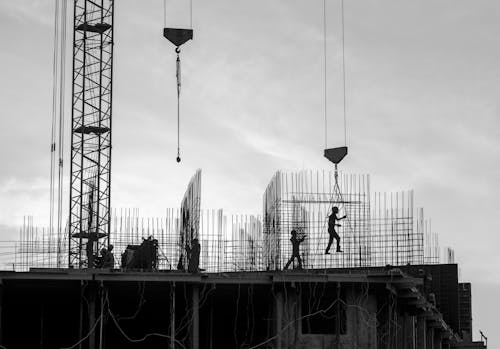 Grayscale Photo of People Working on a Construction Site