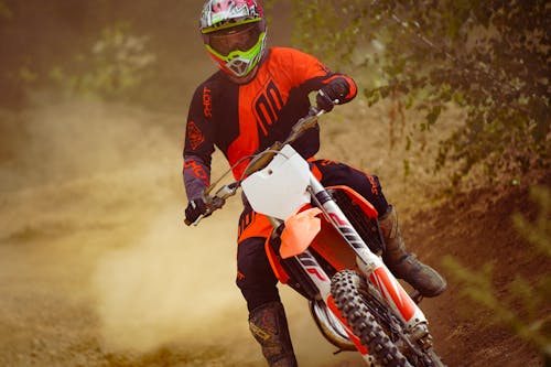 A Man in Motocross Suit Riding a Dirt Bike