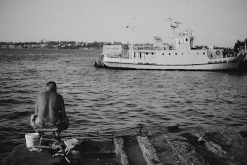 Free Grayscale Photo of Man Fishing on the Ocean Stock Photo