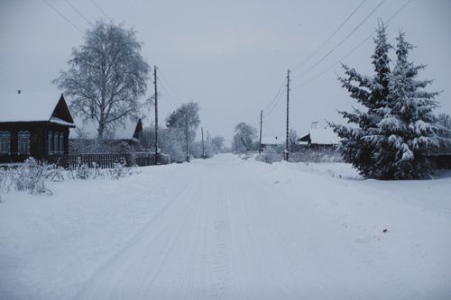 Free Serene winter landscape with snow-covered houses and trees. Stock Photo
