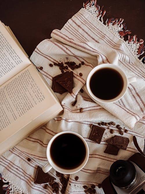 Free Close-Up Shot of Cups of Coffee beside a Book Stock Photo