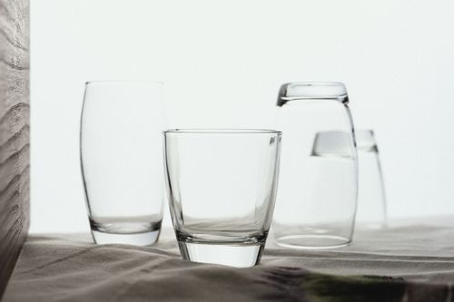 Free Elegant close-up of various drinking glasses arranged on a smooth fabric surface. Stock Photo