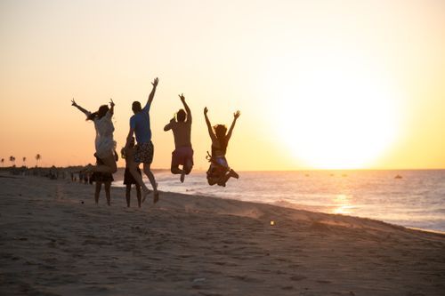 Free Five friends jump and celebrate on a beach at sunset in São Miguel do Gostoso, Brazil. Stock Photo