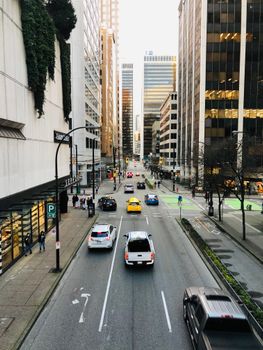 Urban scene of downtown Vancouver with cars and skyscrapers on a busy street.
