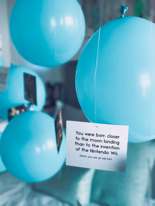 Close-up Photo of Baby Blue Balloons with Letter Card