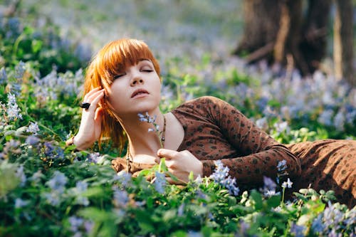Free A Woman Posing While Lying in the Grass Stock Photo