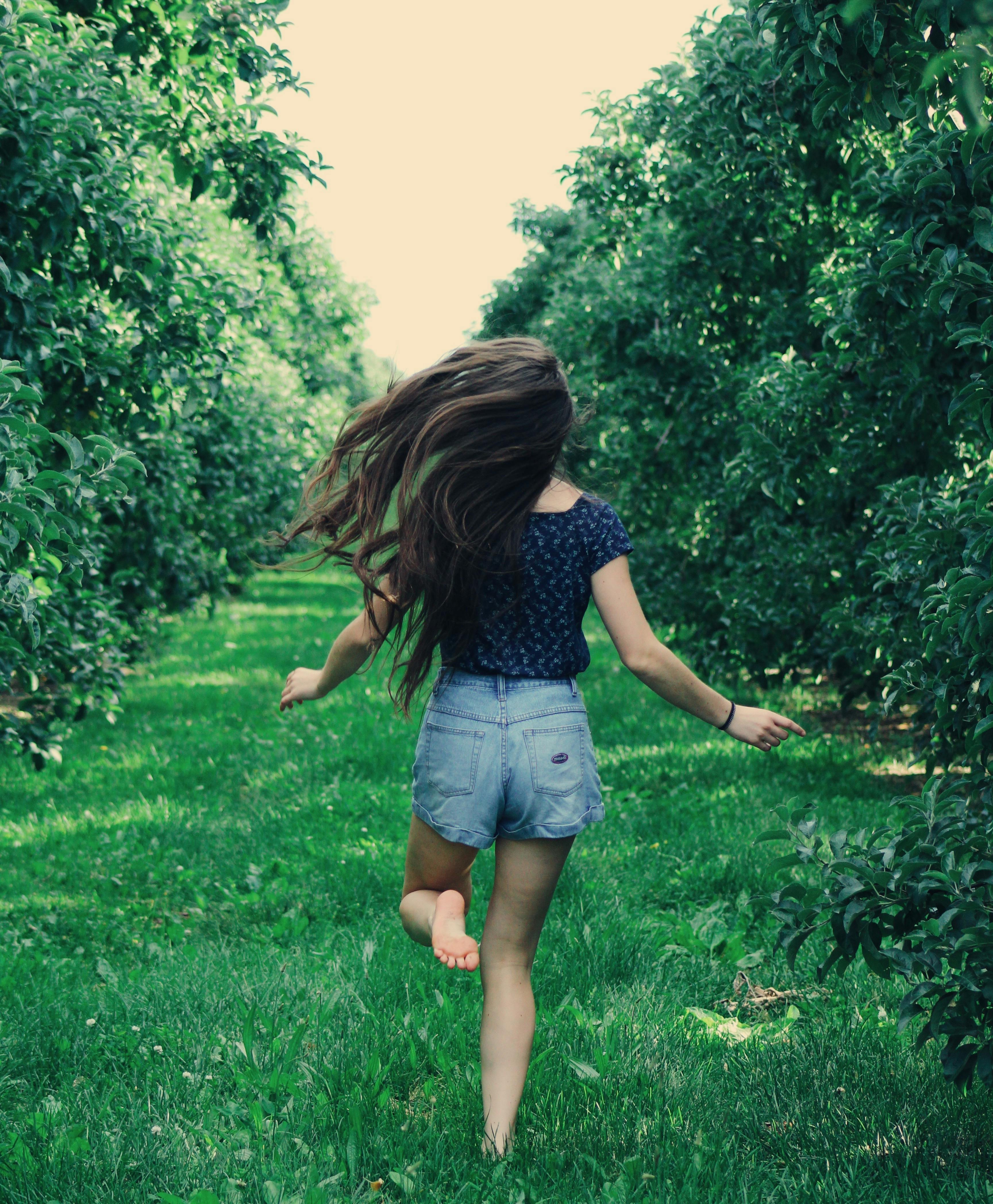 photo of a woman running on green grass