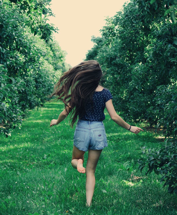 Photo Of A Woman Running On Green Grass