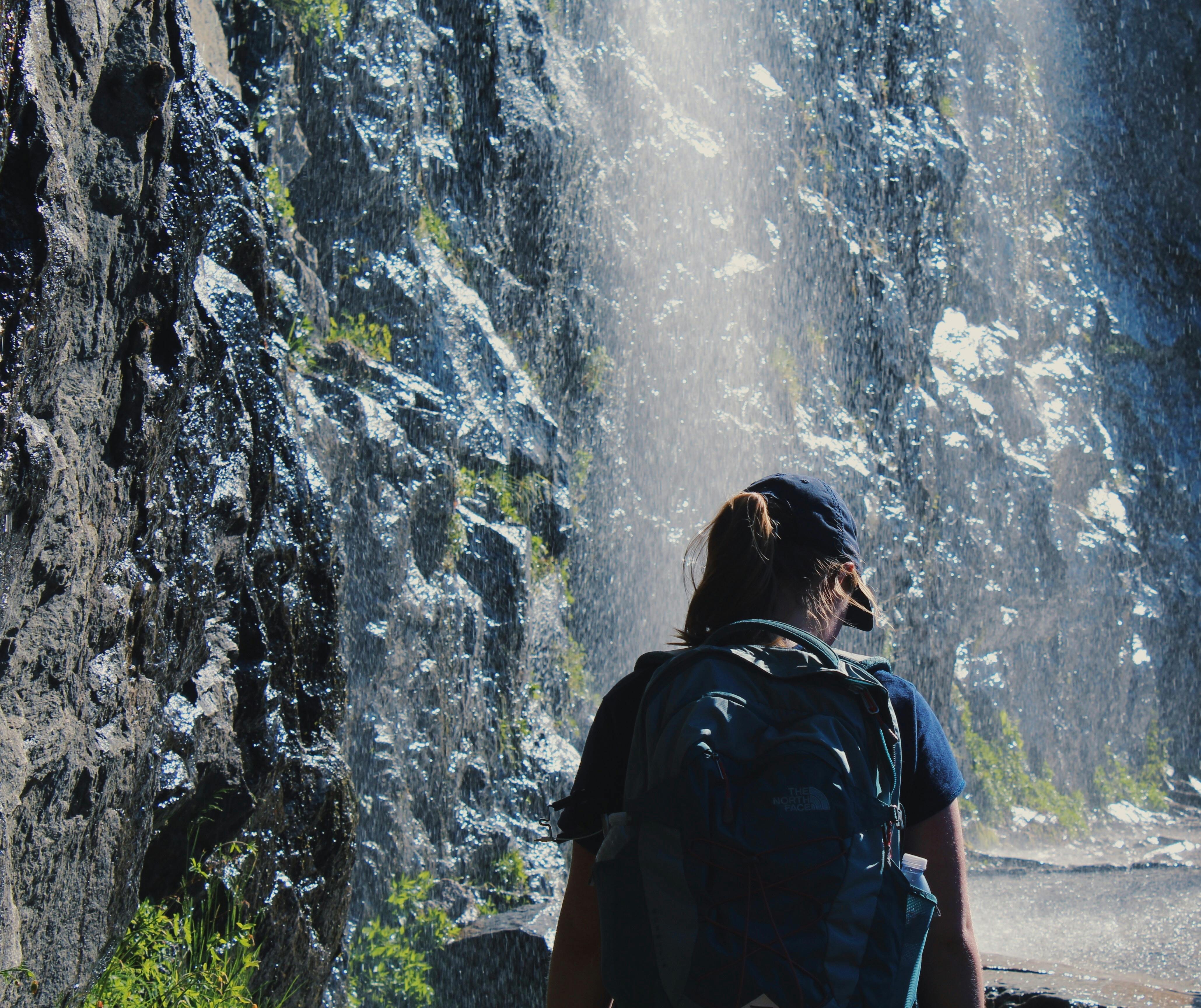 Person Walking Under Waterfalls · Free Stock Photo