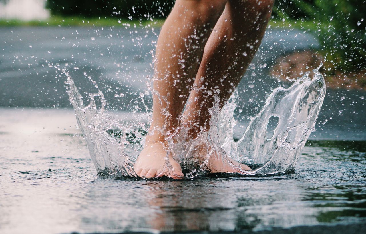 bare feet splashing in a puddle capturing the joy of a rainy day outdo