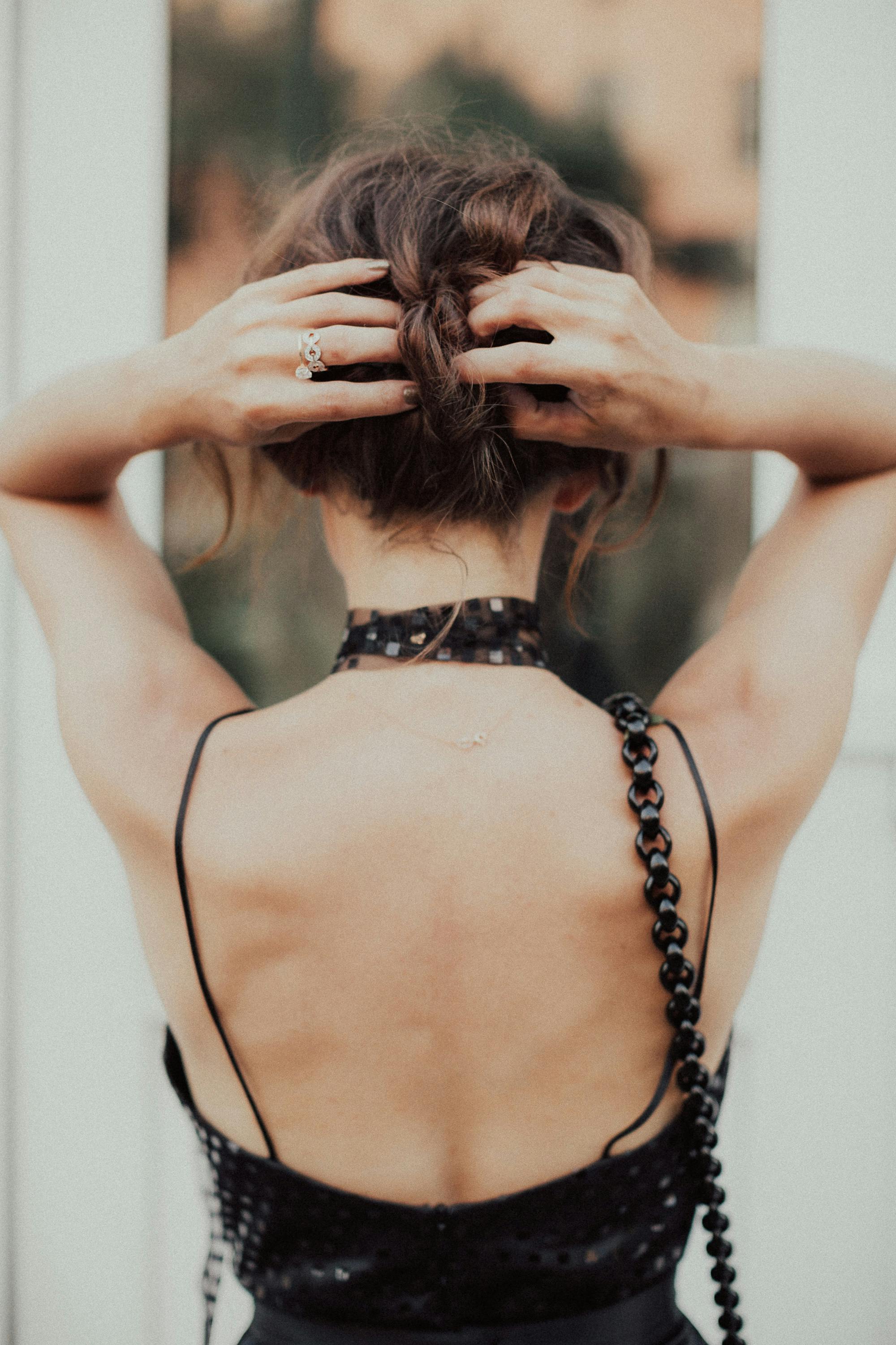A Woman Wearing a Backless Dress Holding Her Hair Free Stock Photo A Woman Wearing a Backless Dress Holding Her Hair Free Stock Photo