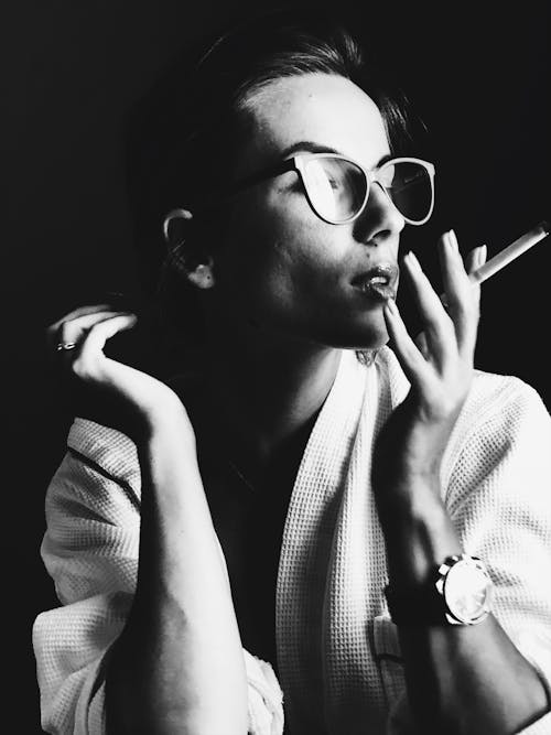 Free 

A Grayscale of a Woman in a Robe Smoking a Cigarette Stock Photo