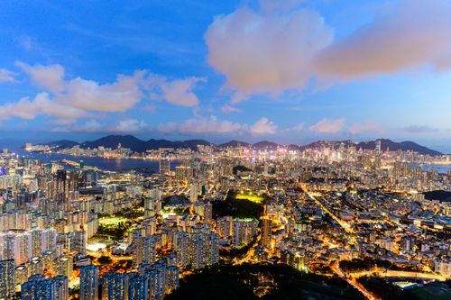 Free Stunning aerial cityscape of Kowloon, Hong Kong at night, brightly illuminated against the evening sky. Stock Photo