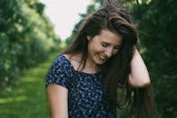 一个快乐的年轻女子在青青的公园里享受阳光明媚的一天