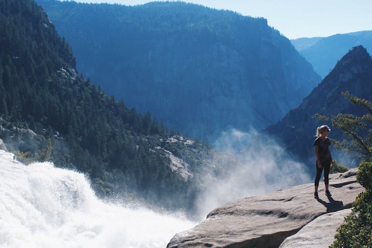 Woman Standing Near Mountain Cliff