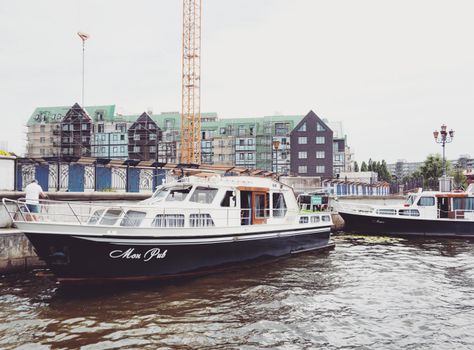 White and Black Boat on Water Near Buildings